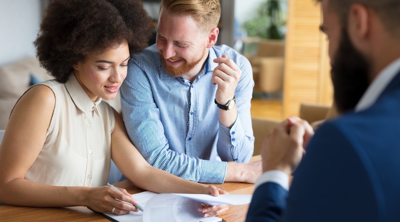 Un couple inspecte un document en souriant